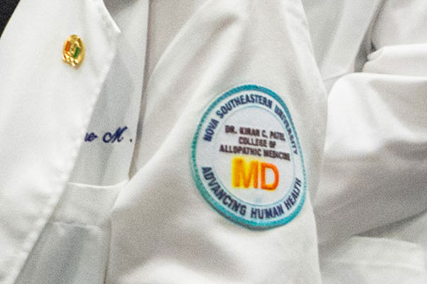 NSU MD badge on white coat